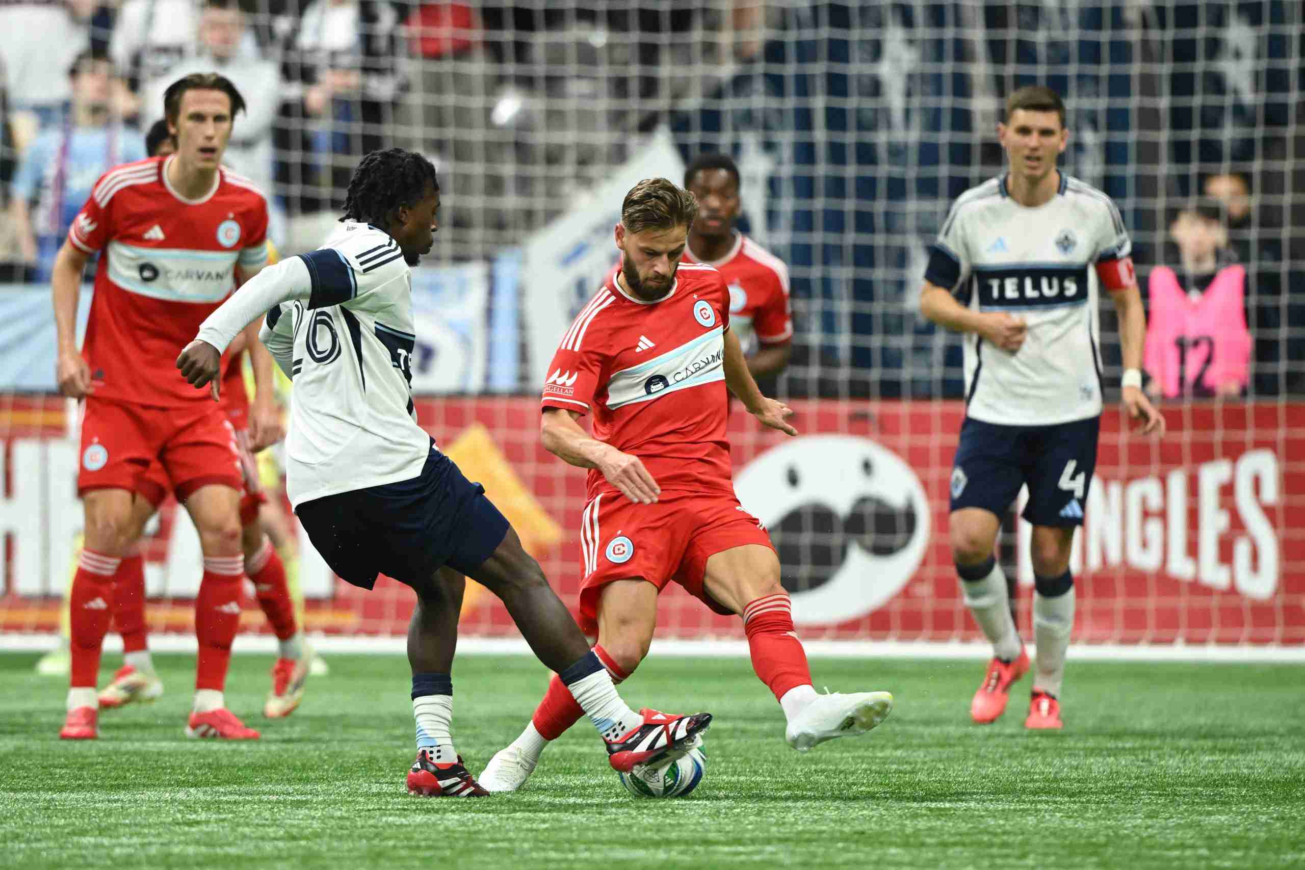 Mar 22, 2025; Vancouver, British Columbia, CAN; Chicago Fire FC forward Philip Zinckernagel (11) defends against Vancouver Whitecaps FC midfielder Jean-Claude Ngando (26) during the second half at BC Place. Mandatory Credit: Anne-Marie Sorvin-Imagn Images